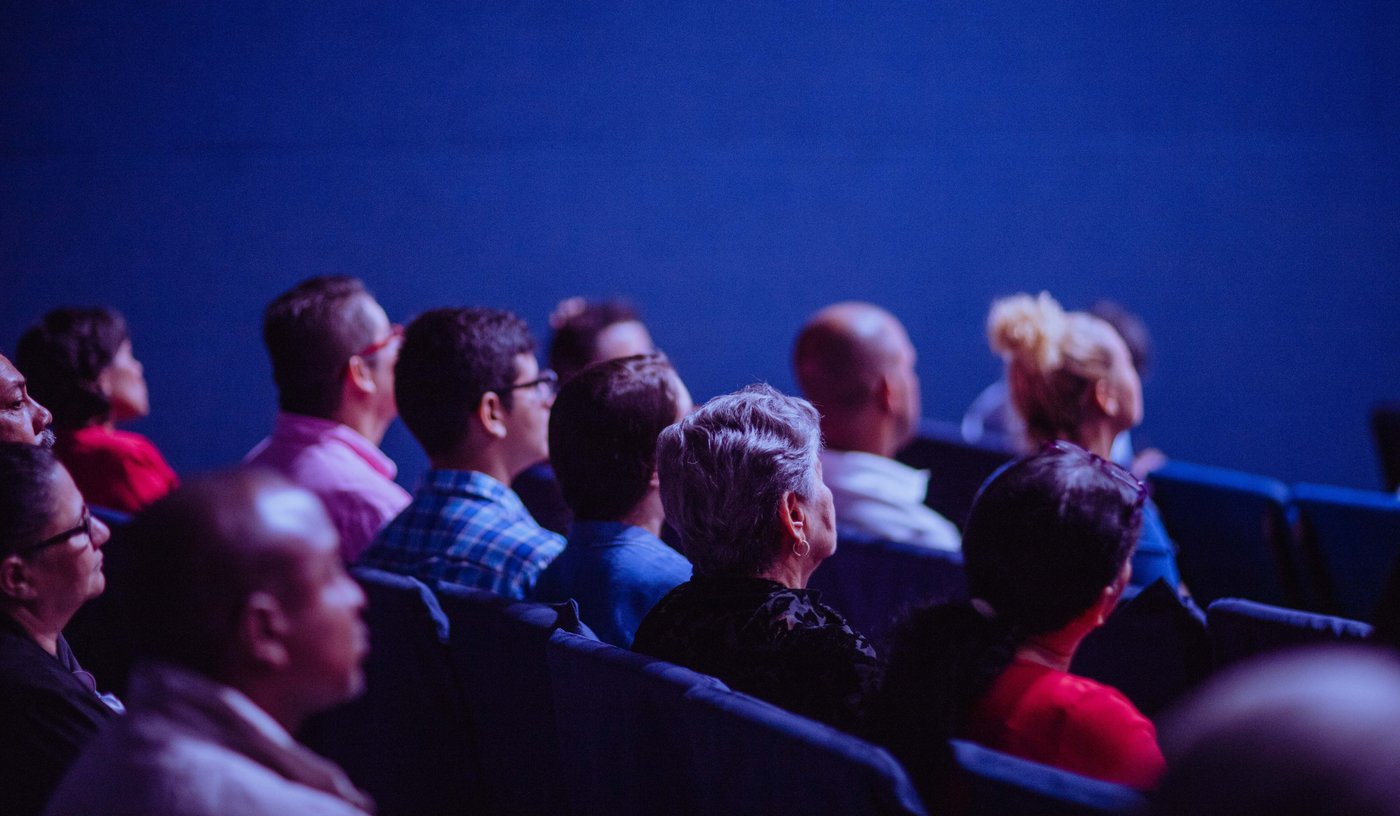 Crowd attend an industry conference and listen to a speaker presenting